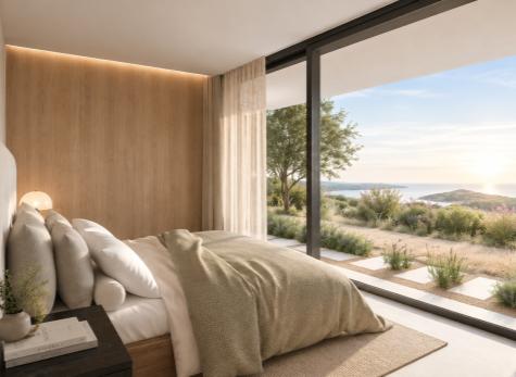 Bedroom with a full-height window towards the sea