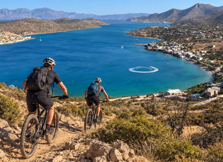 Two cyclists on a coastal track above the gulf